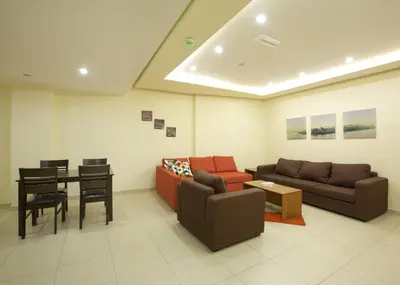 a living room with a couch and a table at Lujain Hotel فندق النور واللجين in Amman