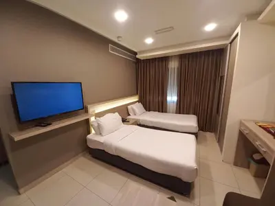 a hotel room with two beds and a flat screen tv at Lujain Hotel فندق النور واللجين in Amman