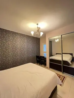 a bedroom with a white bed and a mirror at Thara Real Estate in Sowayma