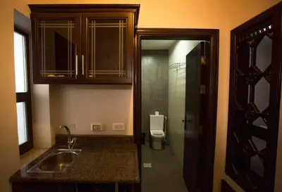 a small kitchen with a sink and a toilet at Thara Real Estate in Sowayma