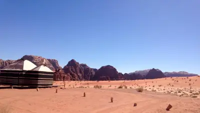 a tent in the desert with mountains in the background at Wadi Rum Camp in Wadi Rum