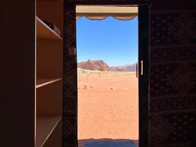 a door to a room with a view of the desert at Wadi Rum Camp in Wadi Rum