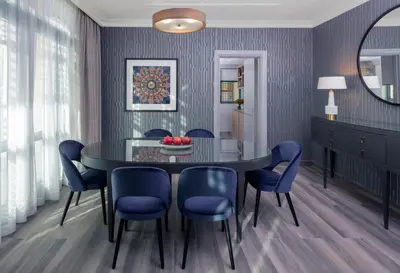 a dining room with a black table and blue chairs at Grand Hyatt Amman Residences in Amman
