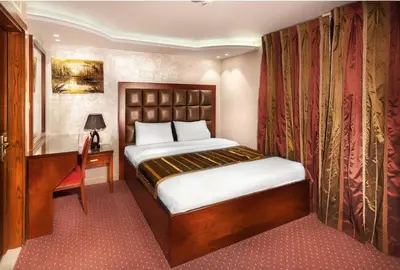 a small bedroom with a bed and a desk at Sofia Hotel in Amman