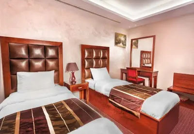 a hotel room with two beds and a mirror at Sofia Hotel in Amman