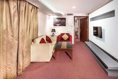 a living room with a couch and a television at Sofia Hotel in Amman