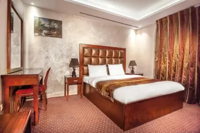 a hotel room with a bed and a desk and a desk at Sofia Hotel in Amman