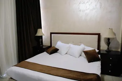 a bedroom with a bed with white sheets and pillows at Madina Suites in Amman