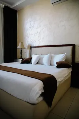 a bedroom with a large bed with white sheets and pillows at Madina Suites in Amman