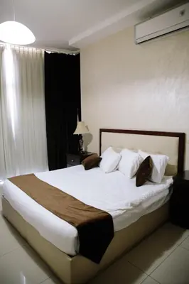 a bedroom with a large bed with white sheets and pillows at Madina Suites in Amman