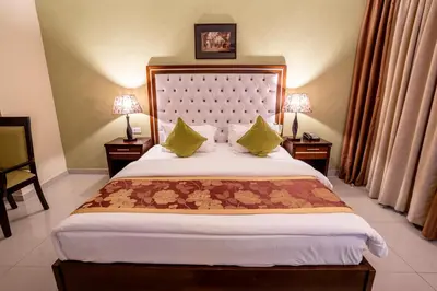 a bedroom with a large bed with two tables and two lamps at P Quattro Relax Hotel in Wadi Musa