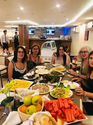 a group of women sitting at a table with food at P Quattro Relax Hotel in Wadi Musa