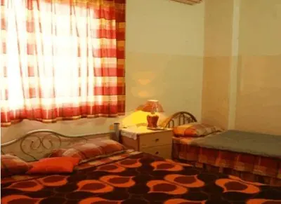a bedroom with two beds and a window at Farah Hotel in Amman