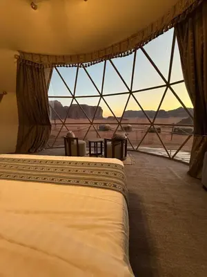 a bedroom with two beds and a large window at Wadi Rum Bedouin Camp in Wadi Rum