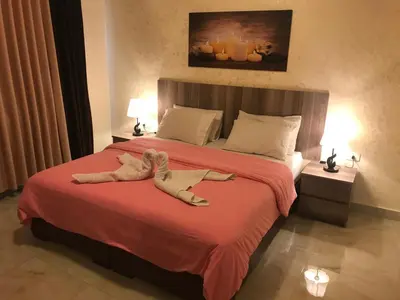 a stuffed animal laying on a bed in a bedroom at Suzan Hotel Apartments in Amman
