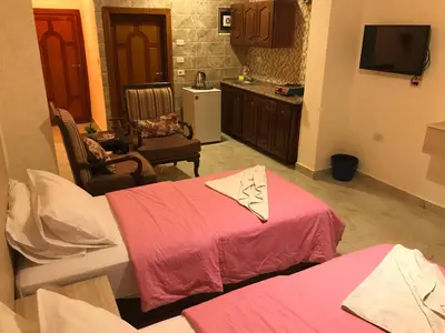 a living room with two beds and a kitchen at Suzan Hotel Apartments in Amman