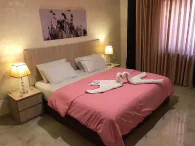 a bedroom with a bed with two towels on it at Suzan Hotel Apartments in Amman