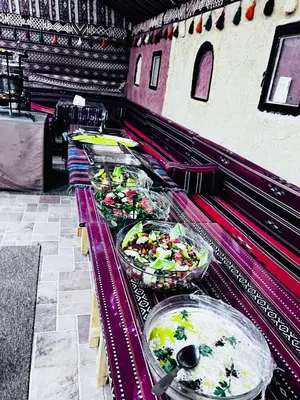 a buffet line with many plates of food at Khaled's Camp - Wadi Rum in Wadi Rum
