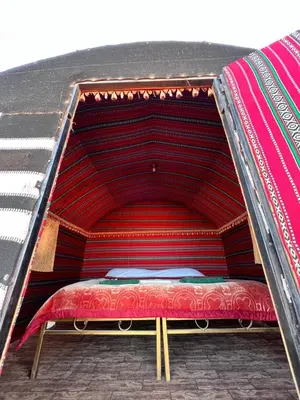 a large bed with a red mattress in a room at Khaled's Camp - Wadi Rum in Wadi Rum
