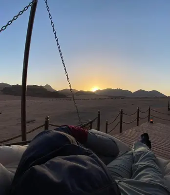 a person laying on a swing in the desert at Rum Stars Camp in Wadi Rum