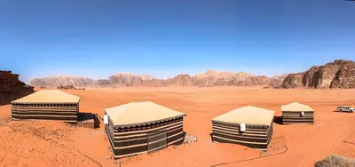 a group of three tents in the desert at Milky Way Bedouin Camp in Wadi Rum