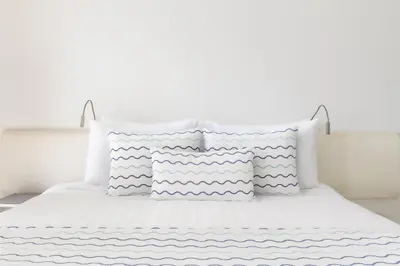a white bed with four pillows on it at Kempinski Hotel Aqaba in Aqaba