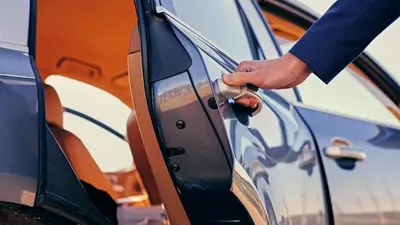 a man opening the door of a car at Kempinski Hotel Aqaba in Aqaba
