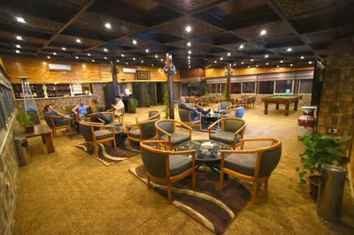 a restaurant with chairs and tables and people sitting at tables at La Maison Hotel in Wadi Musa