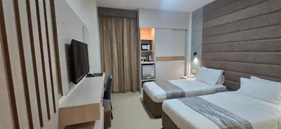 a hotel room with two beds and a television at La Maison Hotel in Wadi Musa