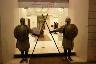 two people in armour standing in front of a store at La Maison Hotel in Wadi Musa