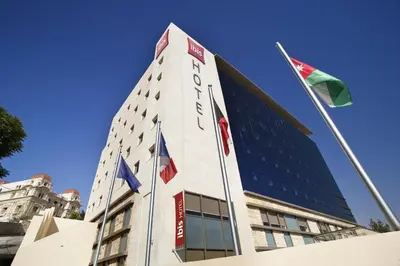 a tall building with flags in front of it at ibis Amman in Amman