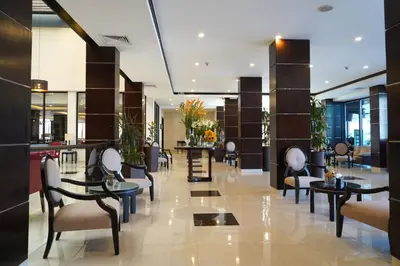 a lobby with chairs and tables in a building at MENA Tyche Hotel Amman in Amman