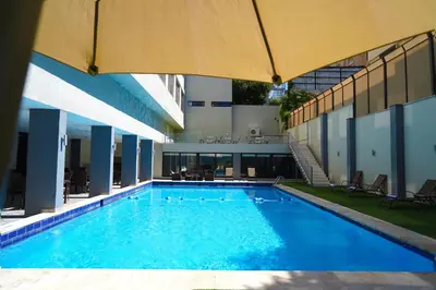 a large swimming pool with blue water in a building at MENA Tyche Hotel Amman in Amman