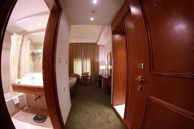 a bathroom with a sink and a door to a room at Sadeen Amman Hotel in Amman