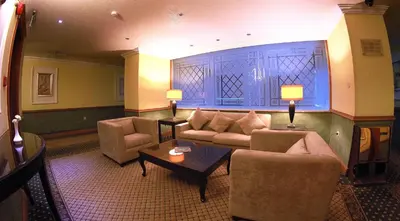 a living room with a couch and chairs and a table at Sadeen Amman Hotel in Amman