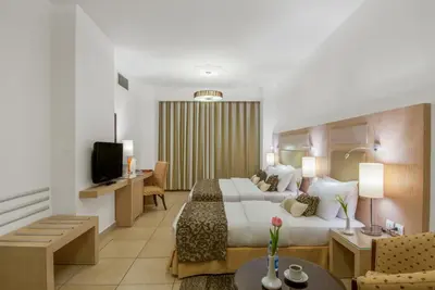 a hotel room with a bed and a living room at Toledo Amman Hotel in Amman