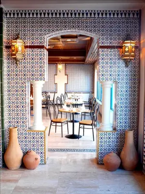 a dining room with a table and chairs and vases at Toledo Amman Hotel in Amman