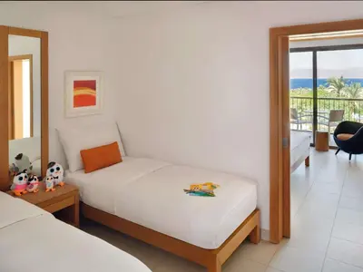 a bedroom with a bed and a view of the ocean at Mövenpick Resort & Spa Tala Bay Aqaba in Aqaba