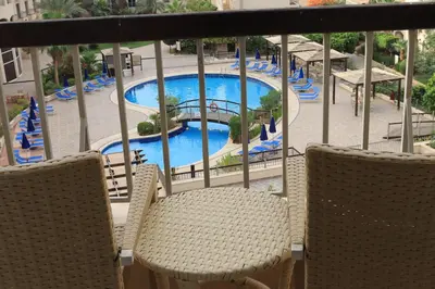 a balcony with chairs and a swimming pool at Dead Sea Spa Hotel in Sowayma