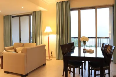 a living room with a table and a chair and a couch at Dead Sea Spa Hotel in Sowayma