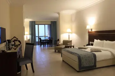 a hotel room with a bed and a living room at Dead Sea Spa Hotel in Sowayma