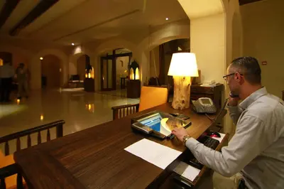 a man sitting at a table with a phone at Ma'in Hot Springs in Sowayma