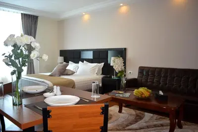 a hotel room with a bed and a table and a dining room at Tilal Almadina Hotel & Suites in Amman