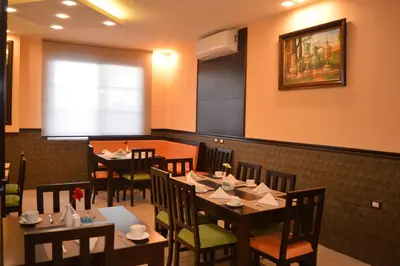 a dining room with tables and chairs in a restaurant at Tilal Almadina Hotel & Suites in Amman