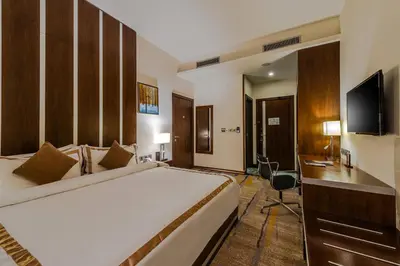 a bedroom with a bed and a desk and a television at Sulaf Luxury Hotel in Amman