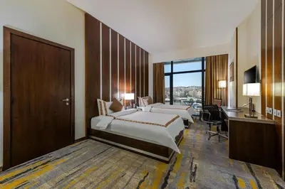 a hotel room with two beds and a desk at Sulaf Luxury Hotel in Amman