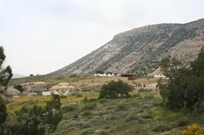 a village on a hill in front of a mountain at Rummana Campsite in Dana