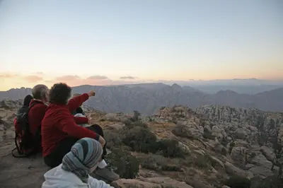 a group of people sitting on top of a mountain at Rummana Campsite in Dana