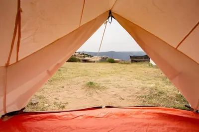a view from the inside of a tent with a field at Rummana Campsite in Dana