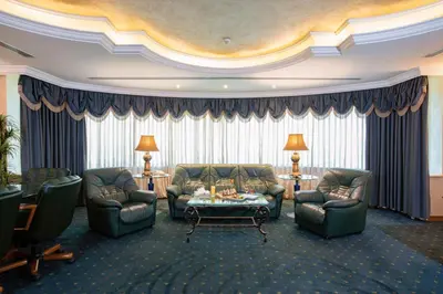 a living room with couches and a table and chairs at Bristol Hotel in Amman